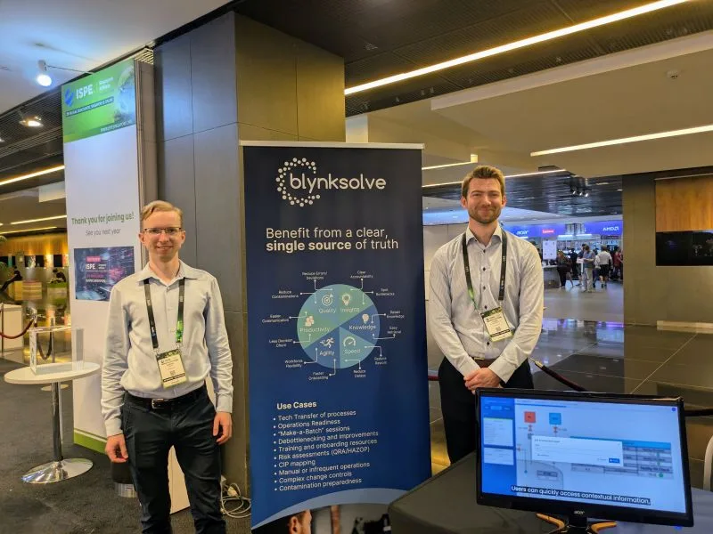 Two people standing beside a Blynksolve display at ISPE Singapore 2024