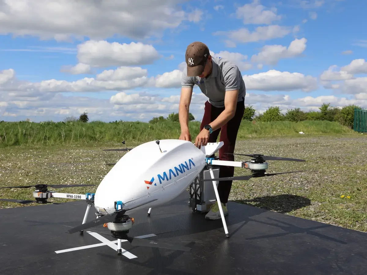 Operator loading a payload into a Manna delivery drone before departure