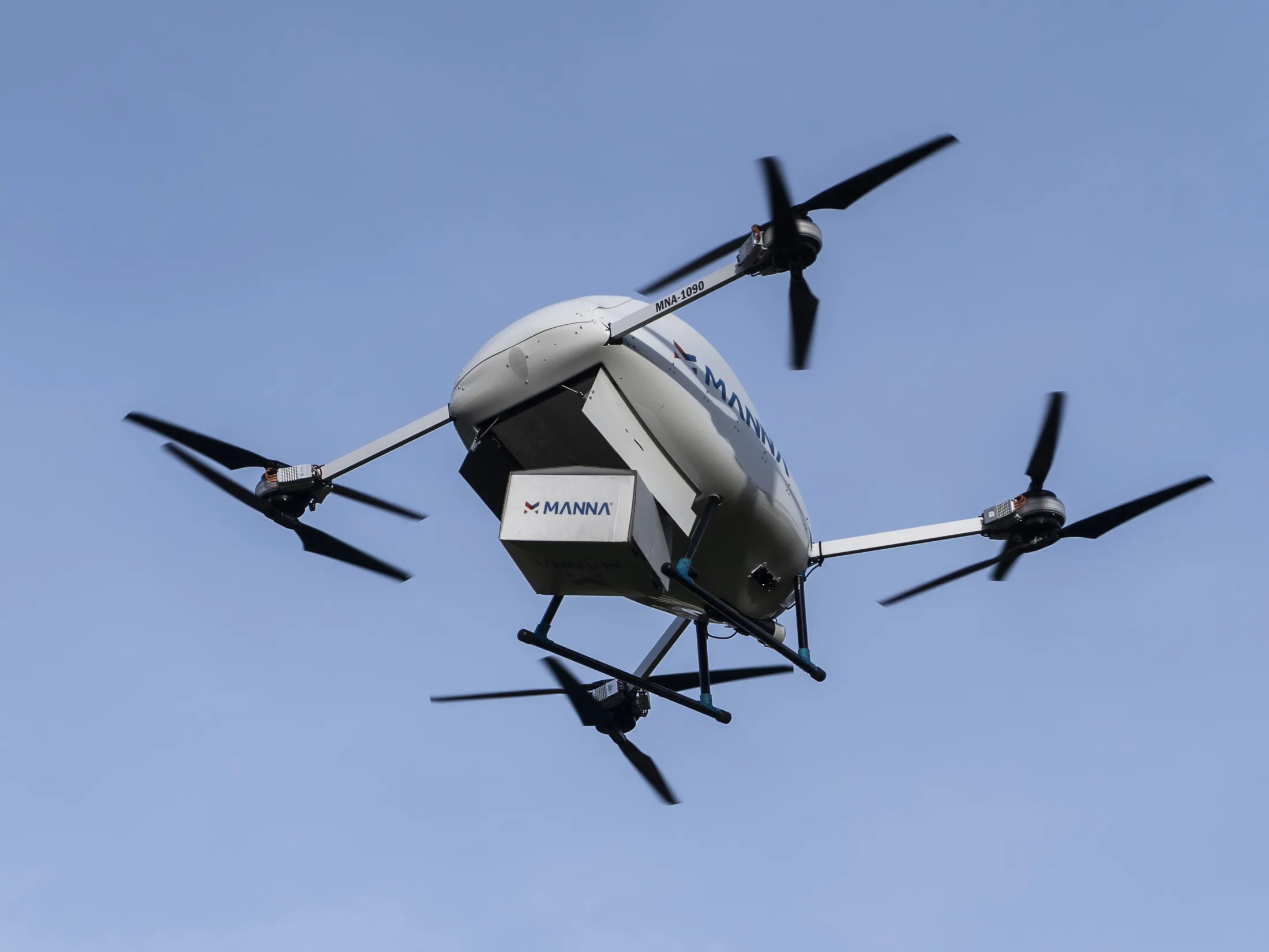 Manna delivery drone in flight carrying a package